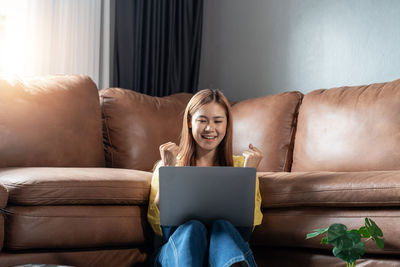 Portrait of young woman using laptop at home