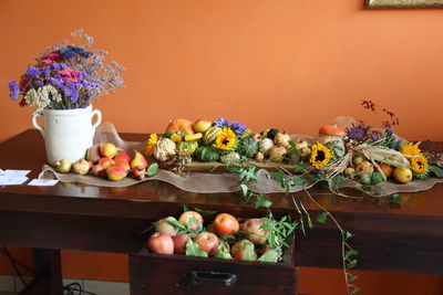 Flower vase on table against wall