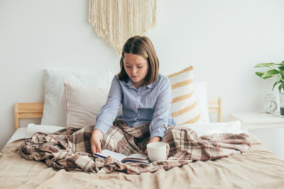 Portrait of young woman sitting at home