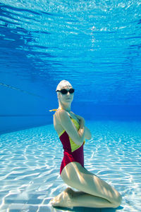 Portrait of young female model posing in pool