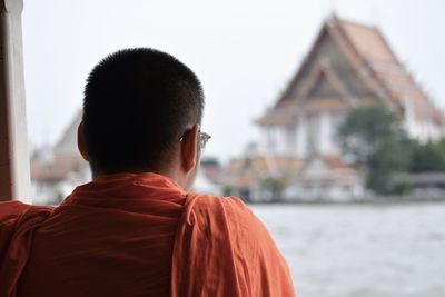 Rear view of man standing against building