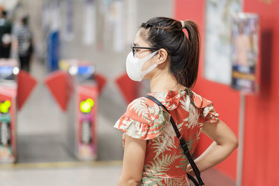 Midsection of woman wearing sunglasses standing outdoors