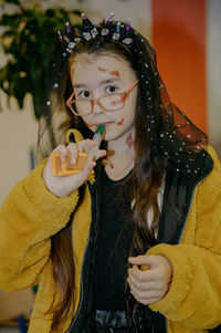 Portrait of a girl with halloween makeup drinking liquid from a syringe.