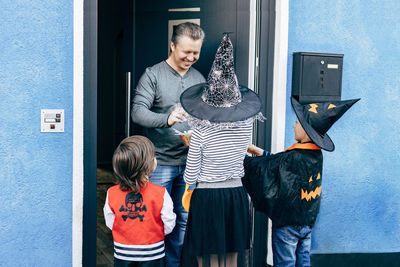 Halloween. children dressed as witch, pumpkin and pirate receive sweets 