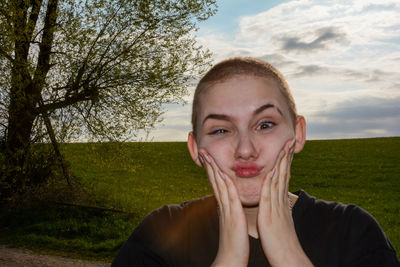 Portrait of young women, hands in the face, against sky