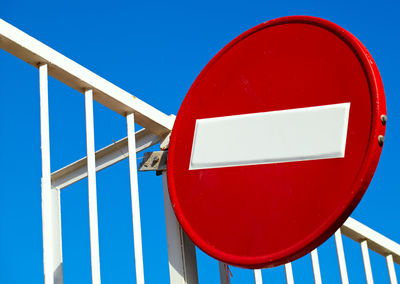 Low angle view of do not enter sign against clear blue sky