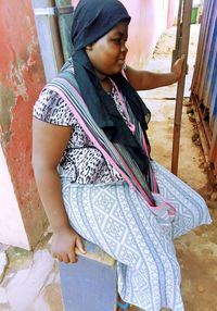 Young woman looking down while standing outdoors