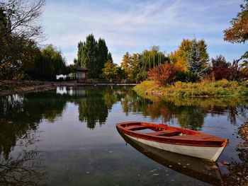 Boat moored in lake against sky during autumn