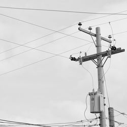 Low angle view of electricity pylon against sky