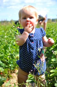 Close-up of happy boy standing on field against sky