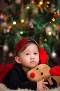 Portrait of cute boy with toy in christmas tree