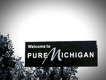 Low angle view of sign board against clear sky