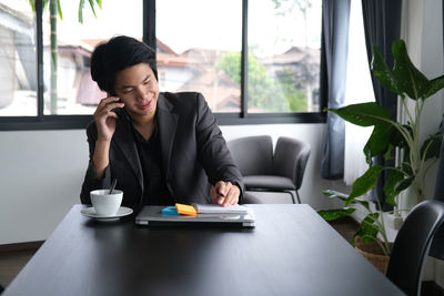 Man talking on phone while sitting in office