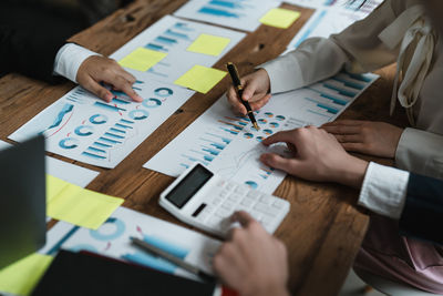 Midsection of business colleagues working on table