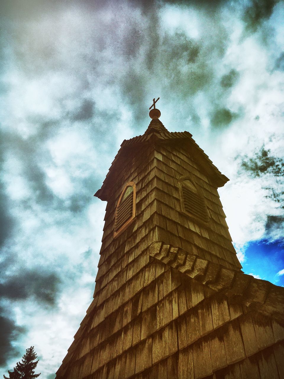 low angle view, architecture, built structure, building exterior, sky, tower, cloud - sky, cloud, tall - high, place of worship, history, outdoors, cloudy, spire, tall, famous place, day, high section, no people, tourism, architectural column, bell tower, medieval, stone material