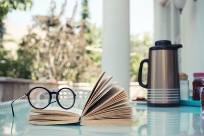 Close-up of glasses on an open books on table