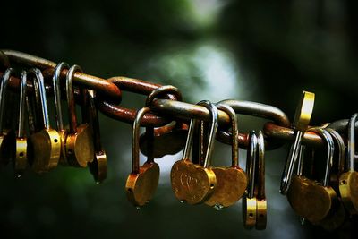 Close-up of love locks hanging to chain