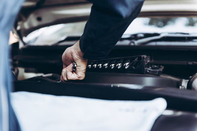 Midsection of man working on car