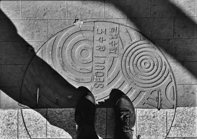 Low section of man standing on manhole