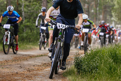 Rear view of man riding bicycle on field