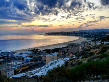 High angle view of city by sea against sky