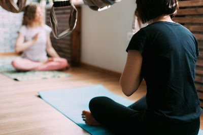 Two women sit on a mat in a yoga class and meditate after a workout. rest, relaxation
