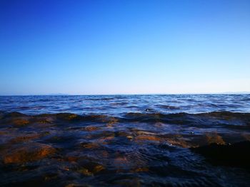 Scenic view of sea against clear blue sky