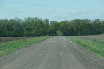 Road amidst trees against sky
