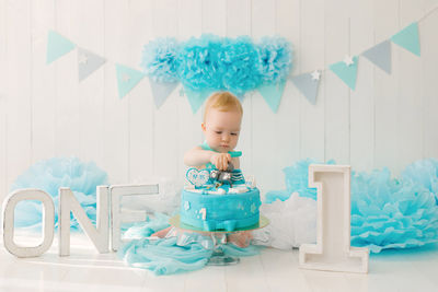 A one-year-old boy tries his first birthday cake