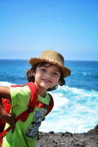Portrait of smiling girl on beach against sky