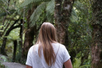 Rear view of woman walking in forest