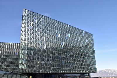 Low angle view of modern building against clear blue sky