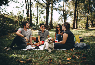 People sitting on dog in forest