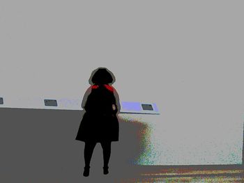 Full length of young woman standing by railing