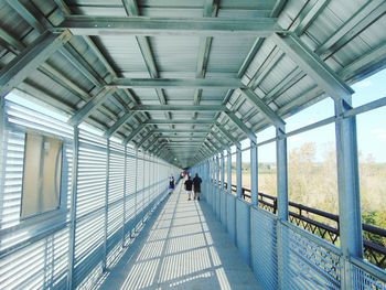 People walking on footbridge in city 