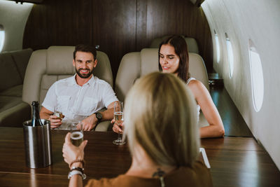 Business people having discussion while sitting in corporate jet