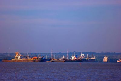 Sailboats in sea against sky