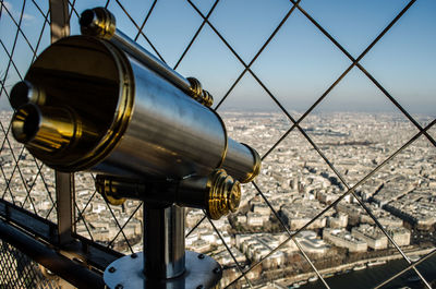 Close-up of coin-operated binoculars against cityscape