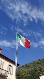 Low angle view of flag against blue sky