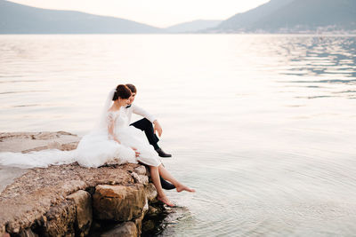 Woman sitting on rock at beach