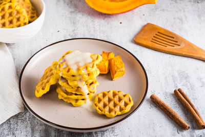 A stack of pumpkin waffles with sweet sauce on a plate on the table. homemade baking.