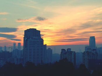 Skyscrapers against sky during sunset