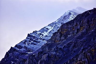 Low angle view of snowcapped mountain against sky