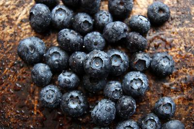 High angle view of wet blueberries on rusty metal