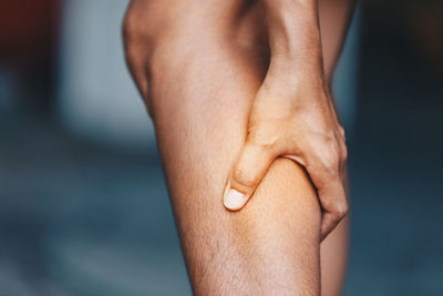 Close-up of man holding aching leg