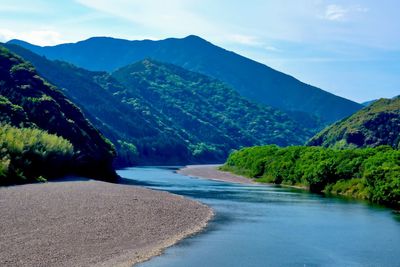 Scenic view of river amidst mountains against sky