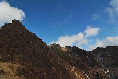 Low angle view of rocky mountains against sky