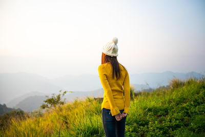 Woman standing on field against sky