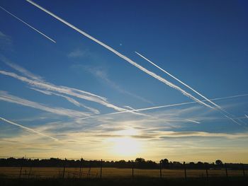 Low angle view of vapor trails against blue sky