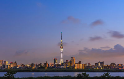 Illuminated buildings in city against sky